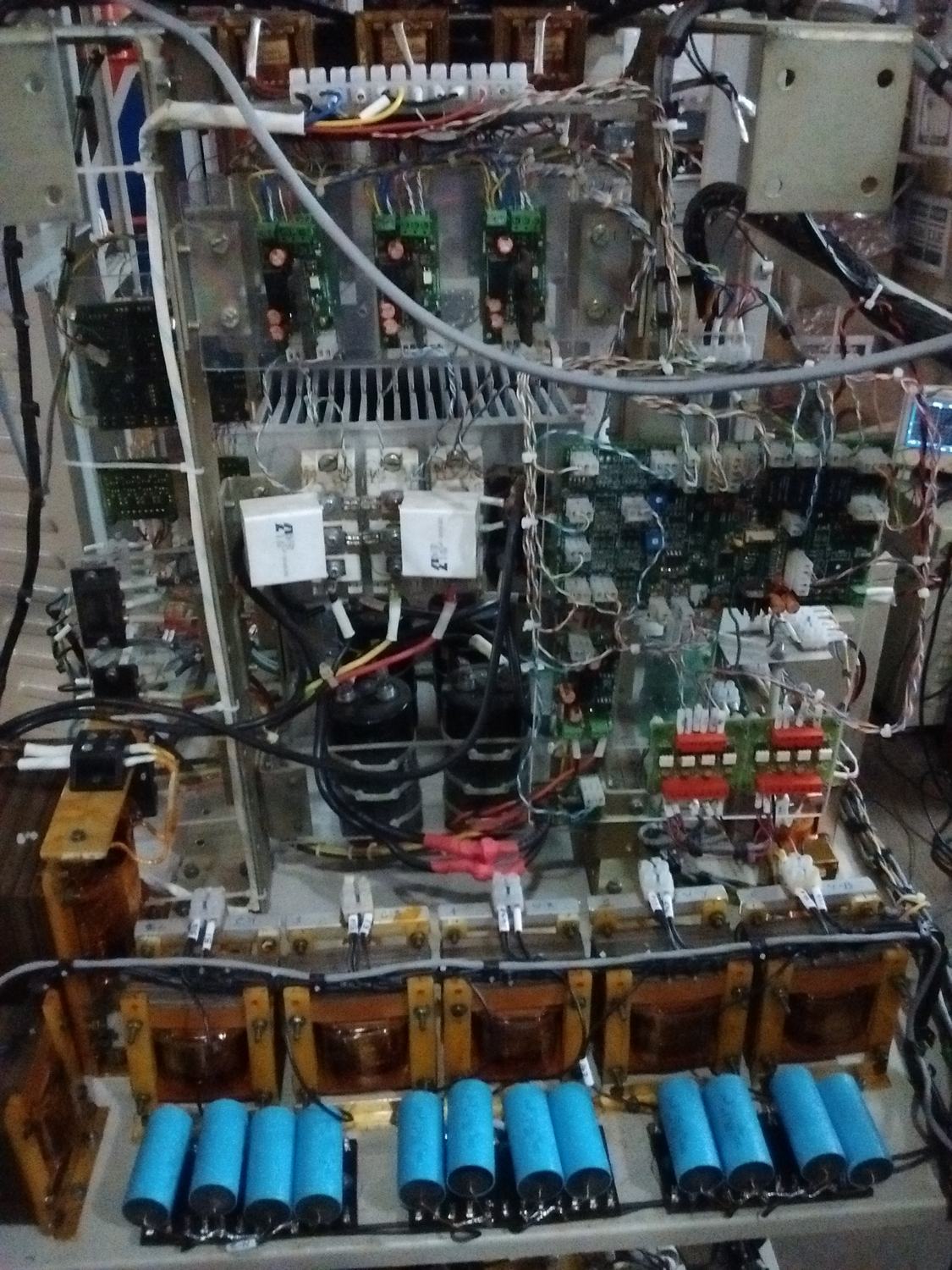 Open chassis of a 15 kW bidirectional inverter prototype with blue capacitors and copper-wound magnetics
